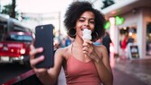Instagram Standort deaktivieren: Frau macht Selfie beim Eisessen