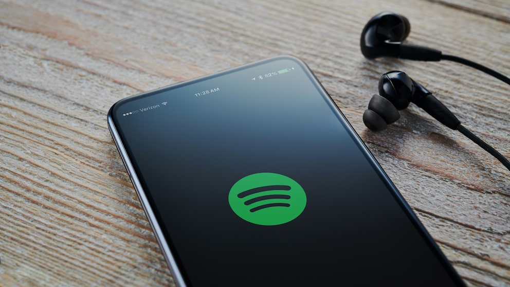 Spotify Logo auf Smartphone mit Kopfhörern