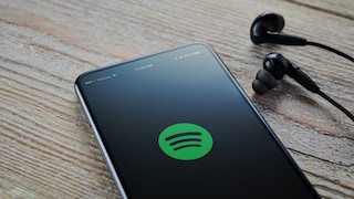 Spotify Logo auf Smartphone mit Kopfhörern