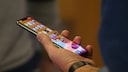 Nutzer schaut auf sein iPhone in der Hand