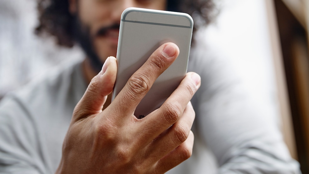 Mann hält Smartphone in der Hand