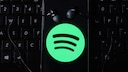 Spotify Logo auf Smartphone mit Kopfhörern auf Tastatur wegen Preiserhöhung