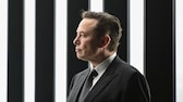 Elon Musk vor schwarz-weißem Hintergrund