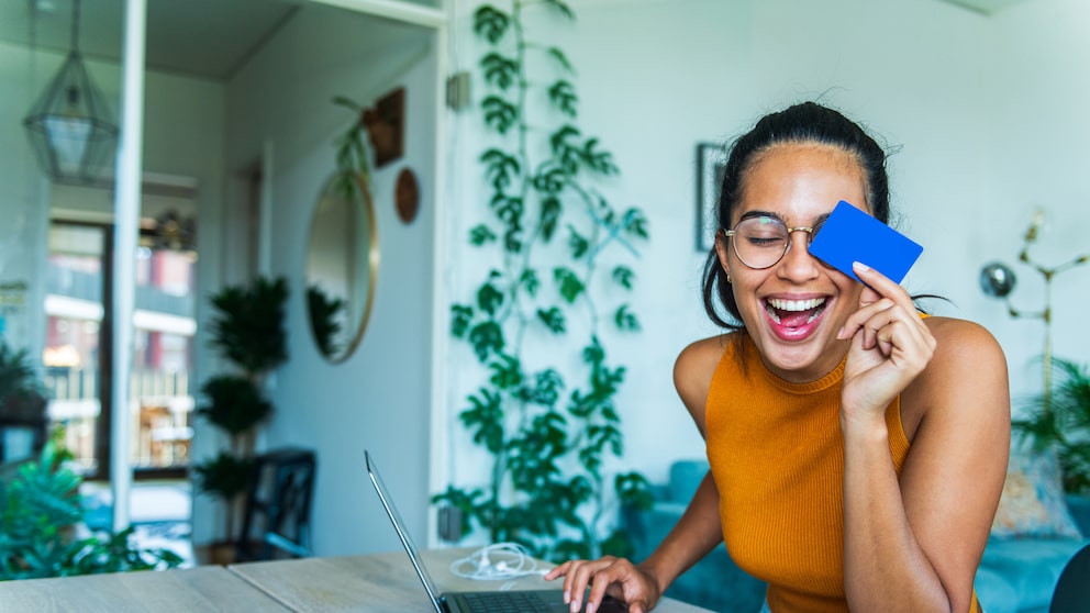 Junge Frau sitzt am Laptop und macht Online-Banking