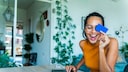 Junge Frau sitzt am Laptop und macht Online-Banking