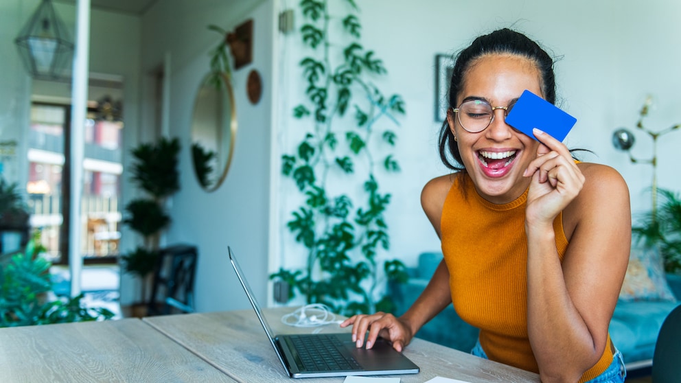 Junge Frau sitzt am Laptop und macht Online-Banking