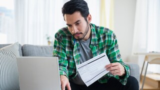 Mann beim Online-Banking vor Laptop.
