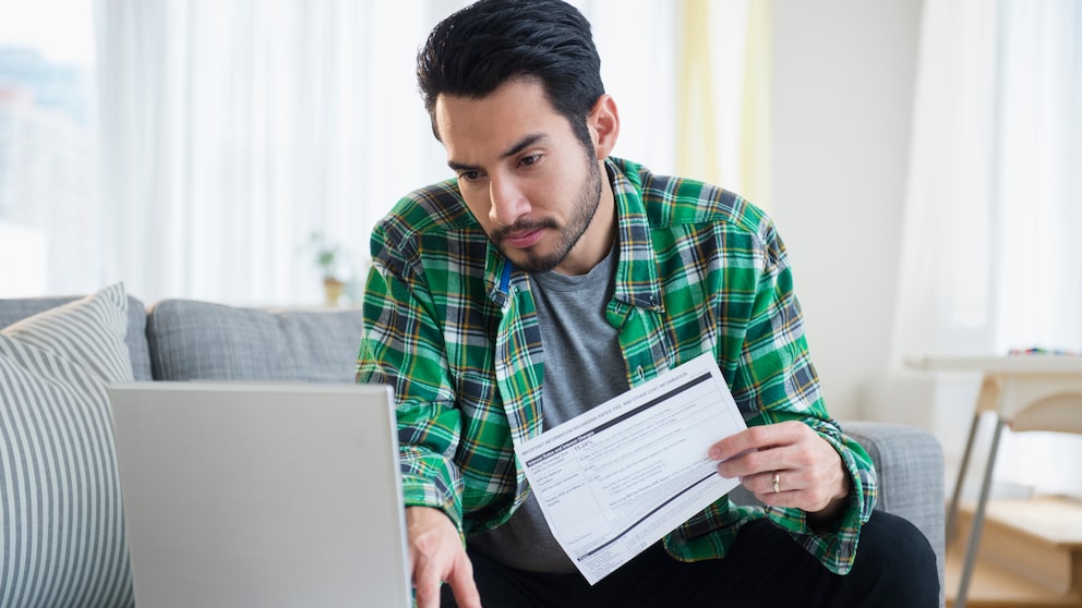 Mann beim Online-Banking vor Laptop.