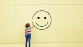 Mädchen malt Smiley an die Wand Geschichte