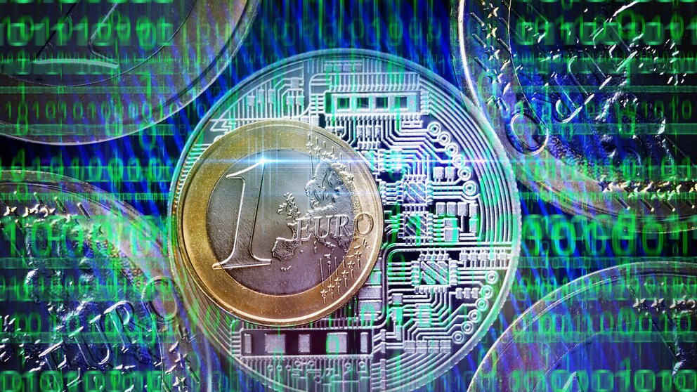 Digitaler Euro Symbolbild: Ein euro Stück vor Motherboard und Nullen und Einsen