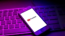 YouTube Premium Logo auf Smartphone, das auf einer Tastatur liegt