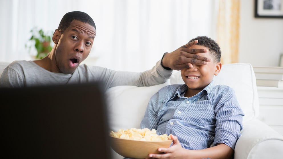Index Filme: Vater hält Sohn vor Fernseher die Augen zu
