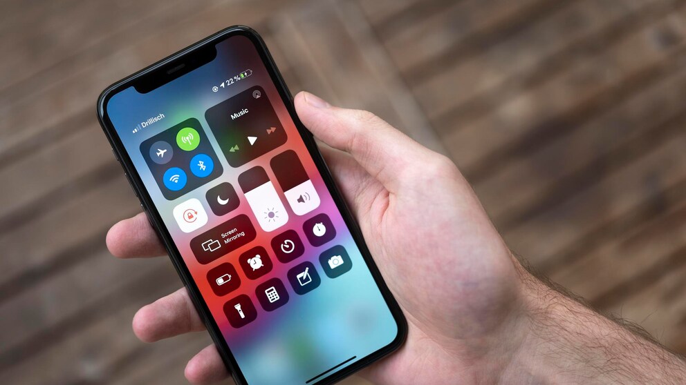 IPhone das auf Werkseinstellung zurückgesetzt wurde in einer Hand vor verschwommenen Boden.