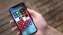 IPhone das auf Werkseinstellung zurückgesetzt wurde in einer Hand vor verschwommenen Boden.
