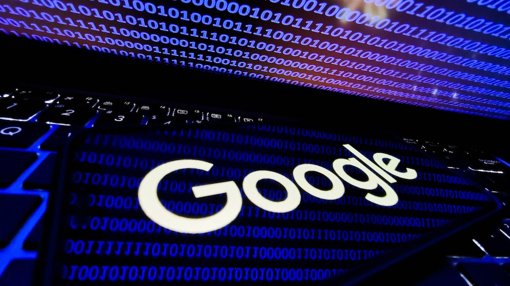 Google-Logo auf einem Smartphone Bildschirm, indem sich binäre Kodes von 1 und 0 von einem Laptop spiegeln. Die Google Suche kann verfeinert werden mit einigen Tipps & Tricks.