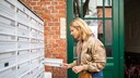 Frau am Briefkasten