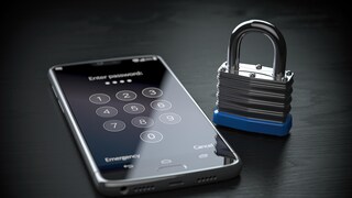 iPhone liegt auf einem Tisch, daneben eine Vorhängeschloss. Denn Apple führt Ende-zu-Ende Verschlüsselung für iCloud ein.