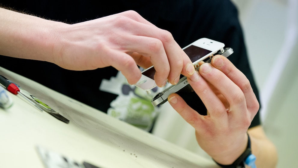 iPhone wird mithilfe des Self-Service-Reperatur-Set auseinander gebaut. Hier wird gerade das Display vom Körper des Smartphone abgenommen.