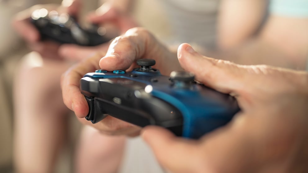 Videospiele 2023 Symbolbild: Close-up von zwei Controllern, die in der Hand gehalten werden