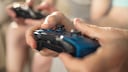 Videospiele 2023 Symbolbild: Close-up von zwei Controllern, die in der Hand gehalten werden