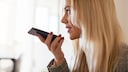 WhatsApp Status Sprachnachricht Symbolbild: Frau spricht in Smartphone