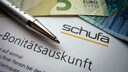 Schufa Speicherdauer Symbolbild mit Schufa-Schriftzug auf Bonitätscheck-Unterlagen