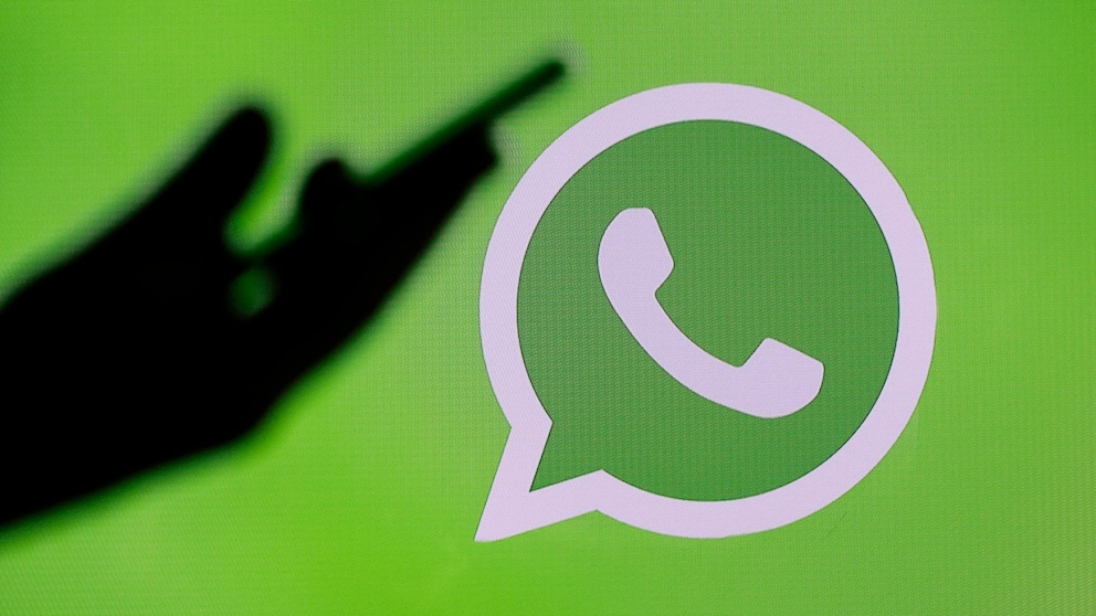 WhatsApp Logo dunkle Hand: unbekannte Anrufe blockieren Symbolbild