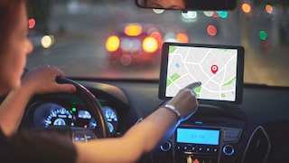Frau nutzt GPS am Navigationsgerät im Auto
