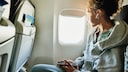 Mädchen mit Bluetooth-Kopfhörern im Flugzeug