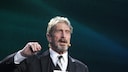 John McAfee 2016 bei einer Konferenz als Redner