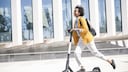 junge Frau fährt E-Scooter