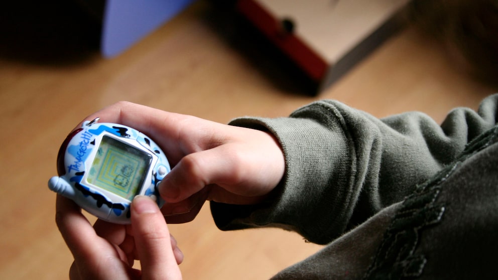 Kind spielt mit Tamagotchi