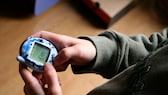 Kind spielt mit Tamagotchi