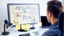 JPG vs JPG Unterschied Symbolbild: Mann schaut sich Bilder am Computer an