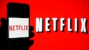 Netflix Werbe Abo Symbolbild: Netflix Logo auf rotem Hintergrund und auf Smartphone