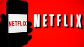 Netflix Werbe Abo Symbolbild: Netflix Logo auf rotem Hintergrund und auf Smartphone