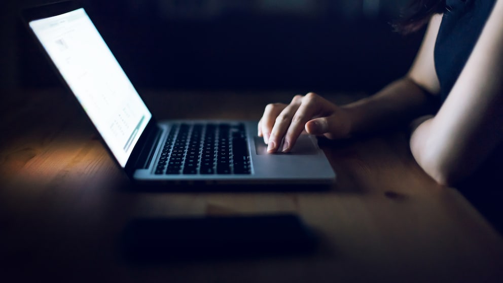 Europol Telefon E-Mail Symbolbild: Frau im Dunkeln am Laptop