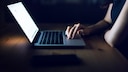 Europol Telefon E-Mail Symbolbild: Frau im Dunkeln am Laptop