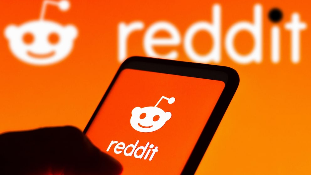 Smartphone mit Reddit Icon von orangenem Hintergrund