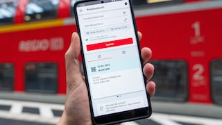 Smartphone mit DB Navigator vor Regionalzug