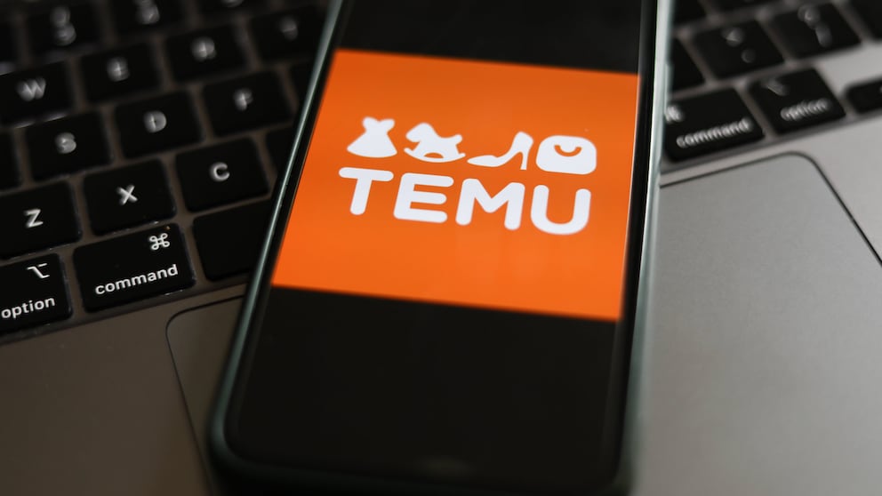 Online-Shop Temu: Logo auf Smartphone, das auf einer Tastatur liegt