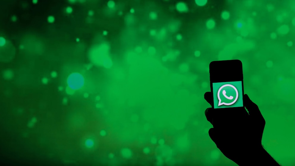Symbolbild: Smartphone mit WhatsApp-Symbol vor grünem Hintergrund