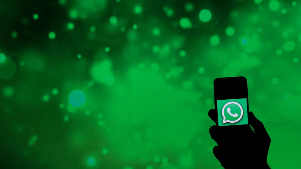 Symbolbild: Smartphone mit WhatsApp-Symbol vor grünem Hintergrund
