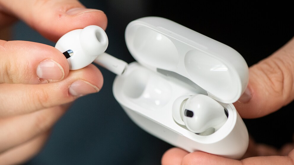 Zwei Hände nehmen AirPods Pro aus dem Case.