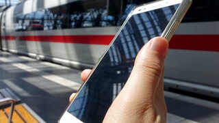 Smartphone vor ICE in Bahnhof