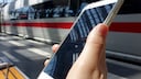 Smartphone vor ICE in Bahnhof