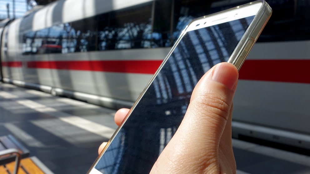 Smartphone vor ICE in Bahnhof