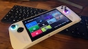 Asus ROG Ally Handheld Konsole im Test auf einem Tisch aus Holz, Tastatur im Hintergrund