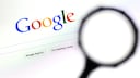 Symbolbild: Google Suche Startbildschirm mit Lupe im Vordergrund