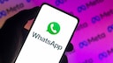 WhatsApp Werbung Symbolbild: WhatsApp-Logo auf Smartphone vor Meta-Logo im Hintergrund
